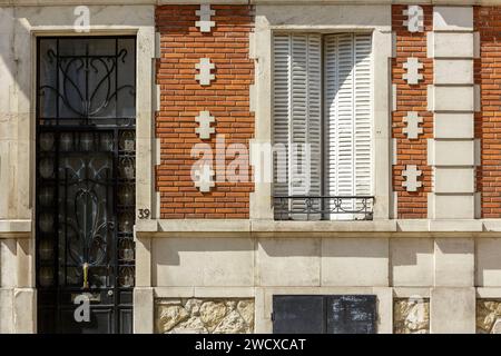 France, Meurthe et Moselle, Nancy, door with ironwork made of wrought iron and facade of a house made of stone and red bricks with crosses of Lorraine as decorations on the facade in Art Nouveau style located Rue Victor Hugo Stock Photo