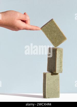 Woman's hand holding a falling bar of natural soap. Handmade cosmetics concept. Stock Photo