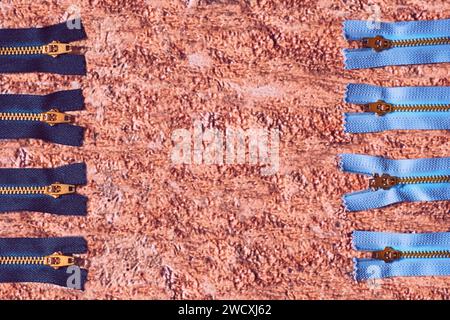 Black and blue zippers for clothes, repair on red brown Stock Photo