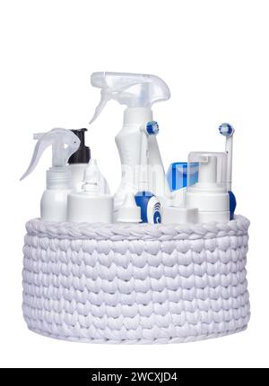 Different plastic bottles and toothbrushes in a white knitted basket isolated on white background. Stock Photo