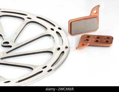 Bicycle brake rotor and new brake pads isolated on a white background. Stock Photo