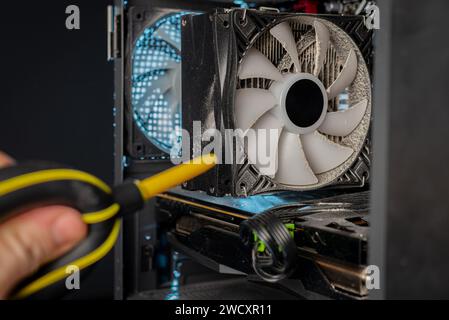 Cleaning the computer video card from dust with a brush and air. Computer fans in dust Stock Photo