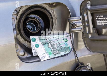 Russian rubles banknotes in the gas tank of a vehicle. Concept photo of the rising fuel price. Fuel economy. High cost of fuel Stock Photo
