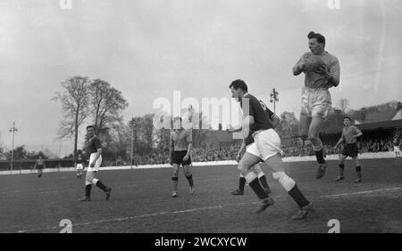 1960, historical, football match, goalkeeper leaping in the air holding the ball at the game between Oxford United and Chelmsford City at the Manor Ground, Oxford, England. Formed as Headington F. C in 1893, the club became Headington United in 1911 and then Oxford United in 1960 when they were in the Premier division of the Southern League, which they won two seasons on a row. In 1962 they were elected (promoted) to the Football League Fourth Division after Accrington Stanley vacated their place. Stock Photo