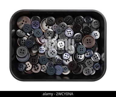 Plastic sew-through buttons, in a black plastic dish. Flat buttons with holes through which thread is sewn to attach the button. Fastener. Stock Photo