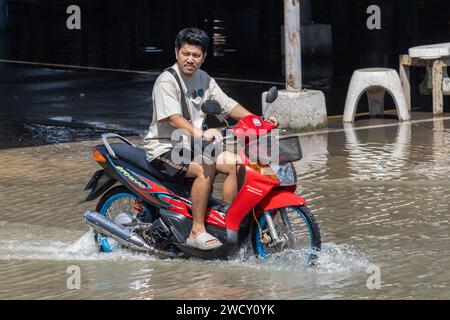 SAMUT PRAKAN, THAILAND, NOV 18 2023, A motorbike rides on a flooded street Stock Photo