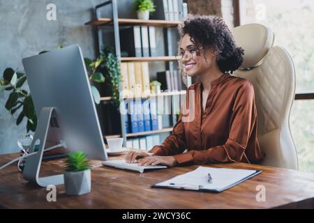 Photo of positive experienced web designer sitting leather chair write keyboard chatting loft interior office inside Stock Photo