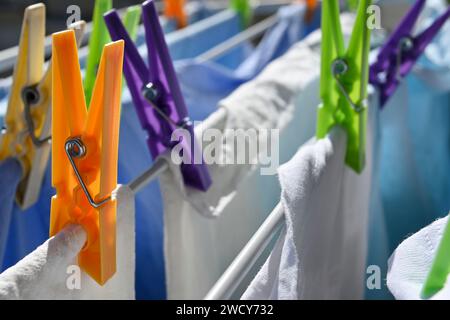 closeup of colorful plastic clothes pegs on rack on a sunny day Stock Photo
