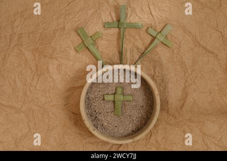 Three palm crosses and ash on braun background. Ash Wednesday concept. Golghota concept Stock Photo