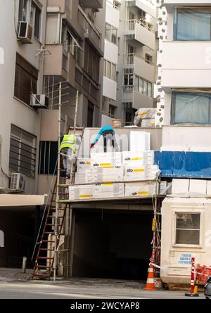 Construction works, Konak Izmir Turkey. workers with cement bags at the facade construction in Izmir construction site Stock Photo
