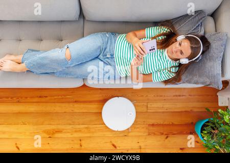 Woman Relaxing with Music and Smartphone at Home Stock Photo
