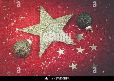 silver Christmas tree baubles and silver star with silver and red stars on a red background, Christmas decoration Stock Photo