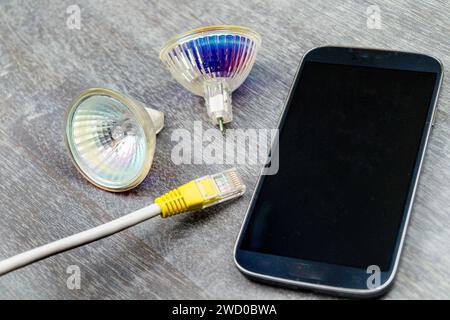 reflector lamps, network cable and smartphone, symbolic image for Smart Home Stock Photo