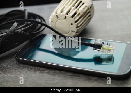 Radiator thermostat, smartphone and network plug, symbolic image for Smart Home Stock Photo