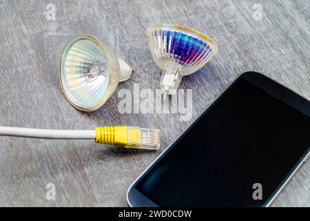 reflector lamps, network cable and smartphone, symbolic image for Smart Home Stock Photo
