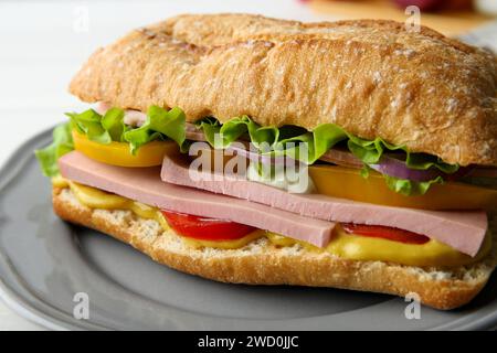 Tasty sandwich with boiled sausage, cheese and vegetables on white ...