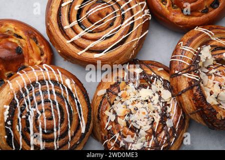 Different delicious rolls on light grey table, flat lay. Sweet buns Stock Photo