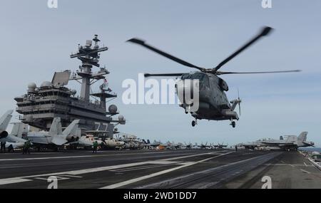 A Royal Navy Merlin Mk2 helicopter lands aboard USS George H.W. Bush. Stock Photo