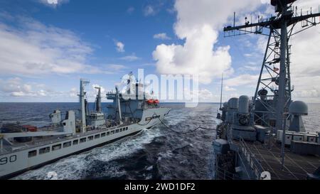 USS Leyte Gulf conducts a replenishment-at-sea with British oiler RFA Wave Ruler. Stock Photo