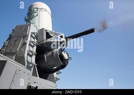 A close-in weapons system fires aboard teh amphbious assault ship USS Kearsarge. Stock Photo