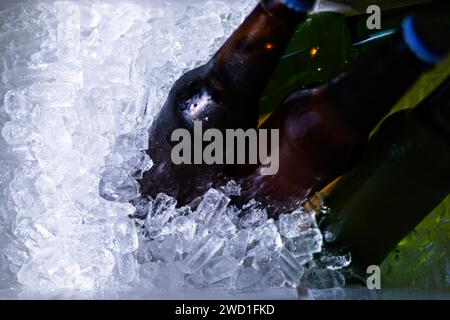 Bucket with bottles of beer and ice cubes, top view. Cubes of ice and colorful bottles with cold beer and drinks. Top view, close-up. Preparation for Stock Photo