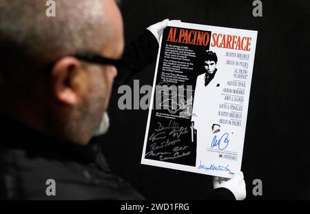 Propstore poster consultant Mark Hochman looks at an Al Pacino, Robert Loggia, Steven Bauer, Mark Margolis, Geno Silva, Mary Elizabeth Mastrantonio and others autographed mini poster for the 1983 film 'Scarface' (estimate £1,000 - £2,000) during a preview for Propstore's UK poster auction at the Propstore in Rickmansworth, Hertfordshire. Picture date: Wednesday January 17, 2024. Stock Photo