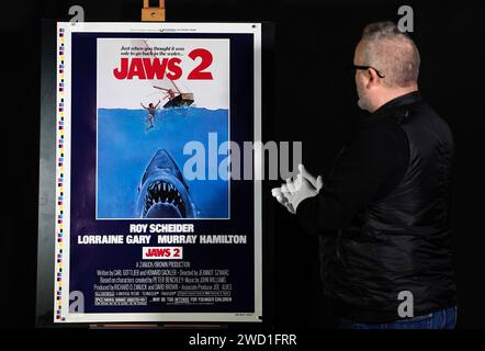 Propstore poster consultant Mark Hochman looks at a printer's test proof US one-sheet sailboat style for the 1978 film 'Jaws 2' (estimate £5,000 - £10,000) during a preview for Propstore's UK poster auction at the Propstore in Rickmansworth, Hertfordshire. Picture date: Wednesday January 17, 2024. Stock Photo