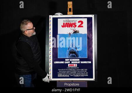 Propstore poster consultant Mark Hochman looks at a printer's test proof US one-sheet sailboat style for the 1978 film 'Jaws 2' (estimate £5,000 - £10,000) during a preview for Propstore's UK poster auction at the Propstore in Rickmansworth, Hertfordshire. Picture date: Wednesday January 17, 2024. Stock Photo