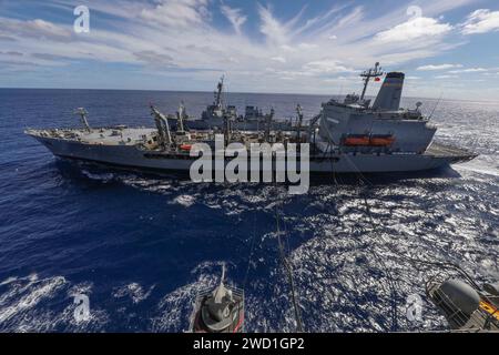 USS Arleigh Burke and USS Iwo Jima conduct an underway replenishment with oiler USNS Kanawha. Stock Photo
