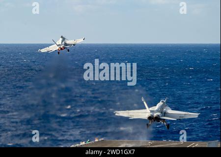 An EA-18G Growler and an F/A-18E Super Hornet launch from the flight deck of USS Ronald Reagan. Stock Photo