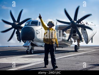 Aviation Boatswains Mate directs the crew of a C-2A Greyhound aboard USS Carl Vinson. Stock Photo