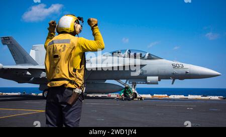 A Sailor assigned to the aircraft carrier USS Carl Vinson directs the crew of an EA-18G Growler. Stock Photo