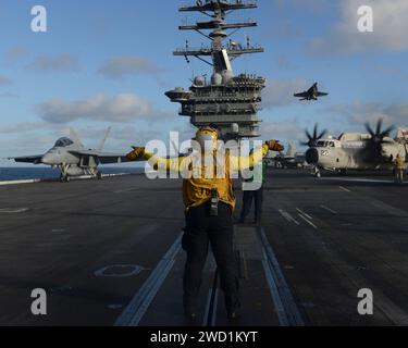 Aviation Boatswain's Mate directs a C-2A Greyhound aboard the aircraft carrier USS Nimitz. Stock Photo