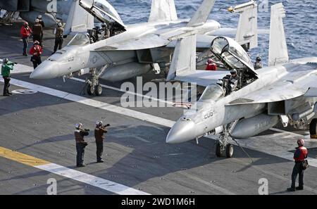 Sailors aboard USS George H.W. Bush signal pilots in preparation for flight operations. Stock Photo