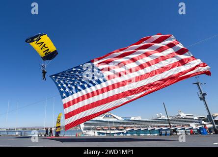 A member of the U.S. Navy Parachute Team, the Leap Frogs, landing on USS Midway with American Flag. Stock Photo