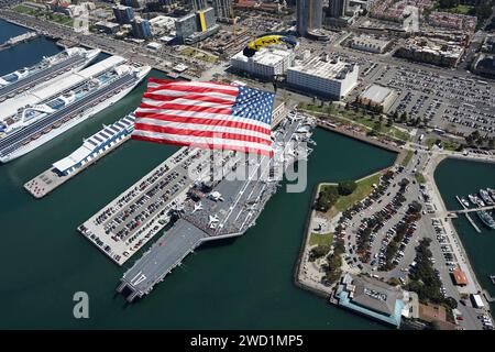 The U.S. Navy Leap Frogs flies with the American Flag above the USS Midway Museum in San Diego, California. Stock Photo