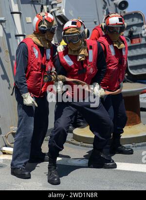 Sailors aboard USS Kidd participate in a crash and salvage drill on the flight deck. Stock Photo