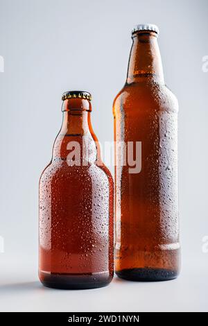 Beer bottle with drops on the gray background. Stock Photo