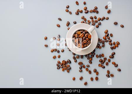 Roasted coffee beans in coffee cup on the gray background. Top view. Stock Photo