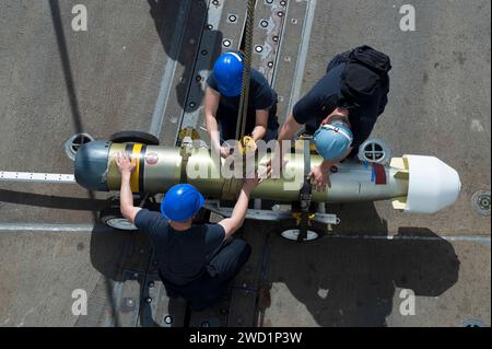 Sailors transport a Mark 46 Mod 5A torpedo across the flight deck of ...