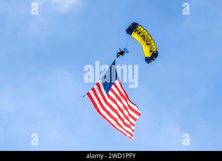 A member of the U.S. Navy parachute demonstration team, the Leap Frogs, flies the American flag. Stock Photo