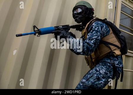 A U.S. Naval ROTC Midshipman provides security while training in an urbanized terrain facility. Stock Photo