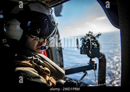 Naval Aircrewman participates in flight operations aboard an MH-60S Sea Hawk helicopter. Stock Photo