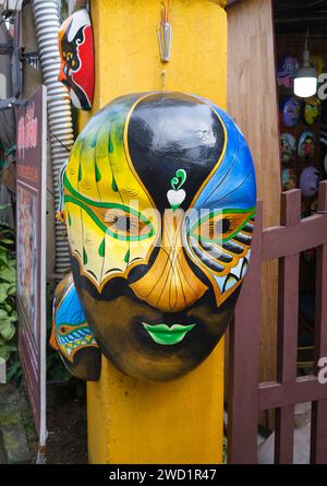 Vietnam: A colourful mask on the front gatepost of The Timing Mask, a company specialising in hand-made masks, Le Loi, Old Town, Hoi An. The small but historic town of Hoi An is located on the Thu Bon River 30km (18 miles) south of Danang. During the time of the Nguyen Lords (1558 - 1777) and even under the first Nguyen Emperors, Hoi An - then known as Faifo - was an important port, visited regularly by shipping from Europe and all over the East. Stock Photo