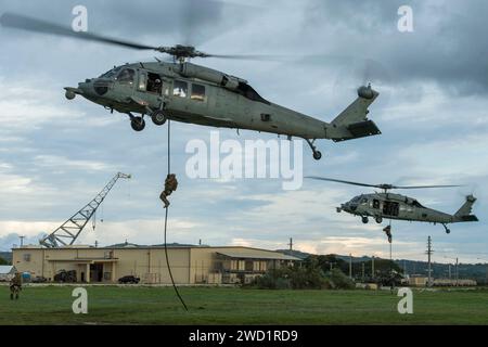 Sailors fast-rope from MH-60S Sea Hawk helicopters at Naval Base Guam. Stock Photo