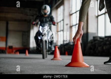 Motorbike driving school lesson with instructor putting cone on track Stock Photo