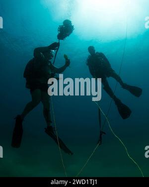 Explosive Ordnance Disposal Technician and a member of the Royal Navy of Oman using a sonar device to locate mines. Stock Photo