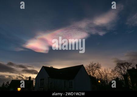 Rare, beautiful, colourful Nacreous clouds (Mother of Pearl clouds / rainbow clouds) in the evening sky over rooftops, Leicestershire, December 2023 Stock Photo