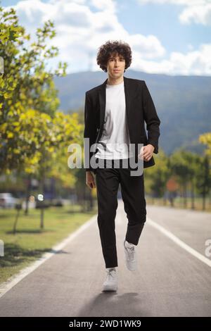 Full length portrait of a tall guy in a suit walking in a city Stock Photo