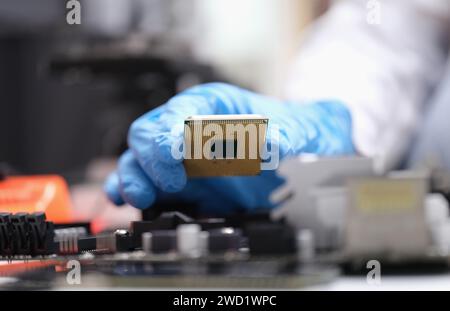 Engineer holds in hands powerful processor or board after repair Stock Photo